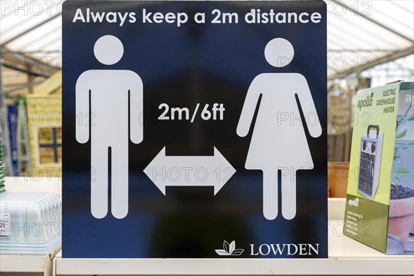 Social Distancing 2 metres apart information notice sign in Lowden garden centre shop, Wiltshire, England, UK, May 2020
