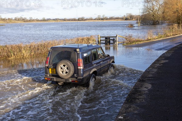 Land Rover Discovery Td5 vehicle driving through flood water at Kellaways, Wiltshire, England, UK 24/12/20