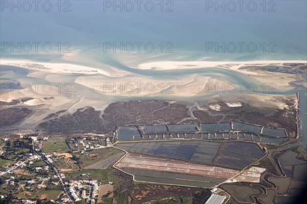 Aerial view of coastline near Faro, Algarve, Portugal showing settlements on coastal plain and offshore sand banks with sandy beaches running along the coast