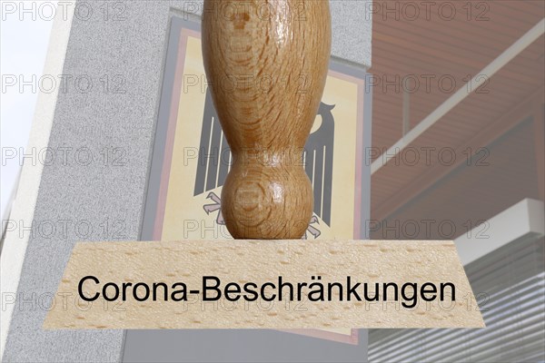 Symbolic image of the constitutional complaint against corona regulations: In the foreground a stamp, in the background the Federal Constitutional Court in Karlsruhe