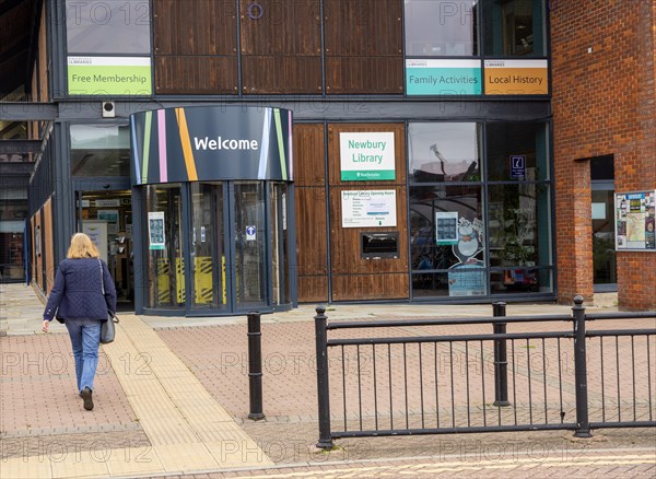 Woman walking towards library entrance door, West Berkshire Libraries, Newbury, Berkshire, England, UK