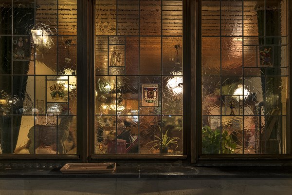 Evening view through the window into an illuminated restaurant, Lauf an der Pegnitz, Middle Franconia, Bavaria, Germany, Europe