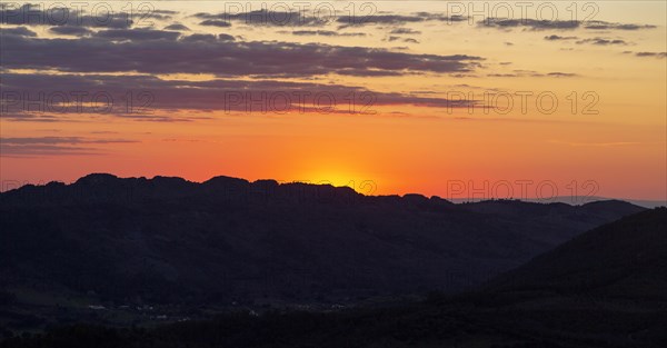 Sunset with glowing sky orange sun dropping behind hills. Photo taken looking south west from Marvao, Portalegre district, Alto Alentejo, Portugal, Southern Europe, Europe