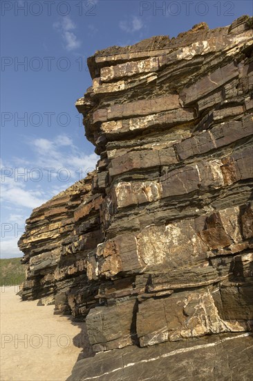 Tilted layers showing bedding planes in strata of sedimentary rock in coastal cliff at Odeceixe, Algarve, Portugal, Southern Europe. Differential erosion is evident due to different layers of rock having differing resistance to erosive force of the sea. Southwest Alentejo and Vicentina Coast Natural Park 29 March 2019, Europe