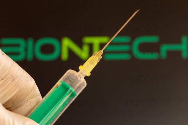 Corona vaccination/Biontech symbol: close-up of an injection needle, with the Biontech logo in the background. The debate about possible vaccine damage is currently gaining momentum in Germany