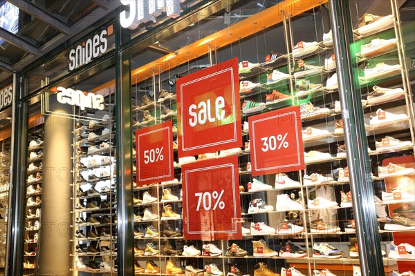 Shop window of the shoe shop Snipes in Mannheim with advertising for big discounts