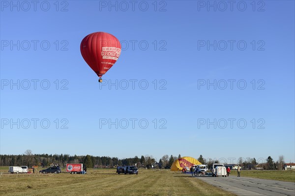 Hot air balloon in the colour red starts at the airfield, Montgolfiade Tegernseer Tal, Balloon Week Tegernsee, Warngau, Bavarian Oberland, Upper Bavaria, Bavaria, Germany, Europe