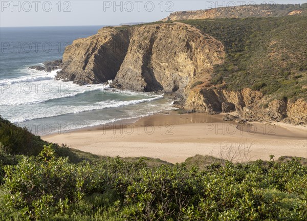 Sandy Carvalhal beach in bay between rocky headlands at Parque Natural do Sudoeste Alentejano e Costa Vicentina, Costa Vicentina natural park, near Brejao, south west Alentejo, Alentejo Littoral, Portugal, Southern Europe, Europe