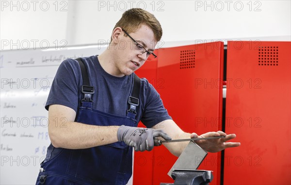 A trainee mechatronics technician works on a workpiece at a Deutsche Bahn training centre, Berlin, 07/02/2024