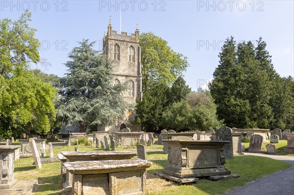 Tower of church of Saint Mary, Berkeley, Gloucestershire, England, UK gravestones and chest tombs in graveyard