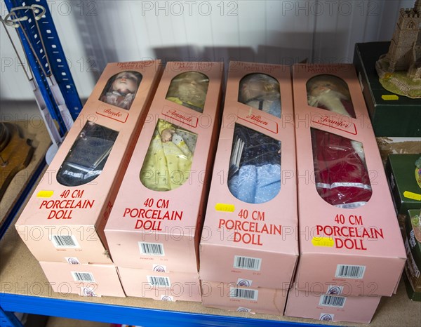 Pink boxes contains porcelain dolls on sale at auction