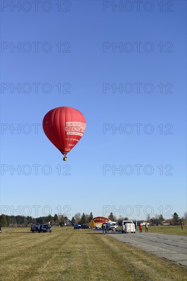 Hot air balloon in the colour red starts at the airfield, Montgolfiade Tegernseer Tal, Balloon Week Tegernsee, Warngau, Bavarian Oberland, Upper Bavaria, Bavaria, Germany, Europe