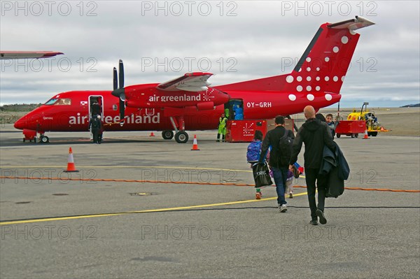 Passengers walk to a propeller plane across a tarmac, Air Greenland, Ilulissat, Greenland, Denmark, North America