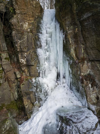 With a free fall height of approx. 9 metres, it is the highest natural waterfall in Saxon Switzerland. In winter, when it freezes, it transforms into a bizarre ice formation, Langhennersdorf, Saxony, Germany, Europe