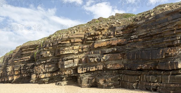 Tilted layers showing bedding planes in strata of sedimentary rock in coastal cliff at Odeceixe, Algarve, Portugal, Southern Europe. Differential erosion is evident due to different layers of rock having differing resistance to erosive force of the sea. Southwest Alentejo and Vicentina Coast Natural Park 29 March 2019, Europe