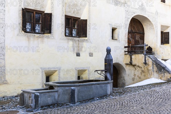 Wooden fountain in front of a historic house, sgraffito, facade decorations, Guarda, Engadin, Grisons, Switzerland, Europe