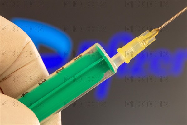 Corona vaccination/Pfizer symbol: close-up of an injection needle, with the Pfizer logo in the background. The debate about possible vaccine damage is currently gaining momentum in Germany