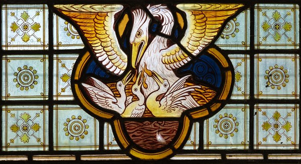 Stained glass window Bedingfield church, Suffolk, England, UK c 1878, detail of pelican feeding its young with its own blood, prob Heaton, Butler and Bayne