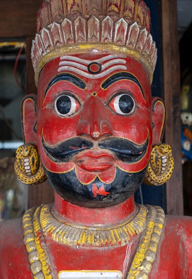 A close-up of a traditional red-faced statue of a man with a mustache, Matancherry, Jew Town, Cochin, Kerala, India, Asia