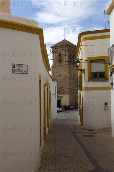 Parish church at end of narrow street of old historic houses in historic village of Nijar, Almeria, Spain, Europe