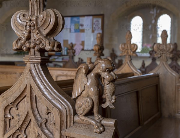 Carved pew bench ends inside All Saints church, Hollesley, Suffolk, England, UK