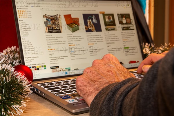 Symbolic image of Christmas shopping on the internet/at Amazon: Christmas decorations and laptop with open screen