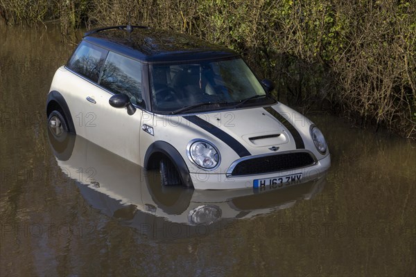 Mini Cooper S car stuck in River Avon flood water, Kellaways bridge, Wiltshire, England, UK 24/12/20