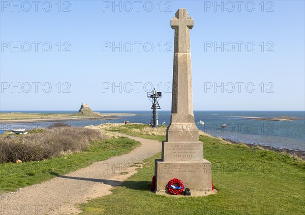 War memorial and Lindisfarne castle North Sea coast, Holy Island, Northumberland, England, UK