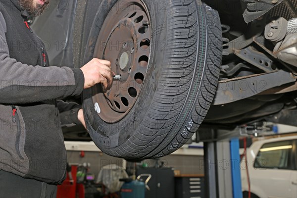 Fitting new all-weather tyres in the garage (editorial)