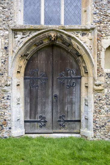 West door Cratfield village parish church, Suffolk, England, UK with spandrel figures of woodwose and wyvern