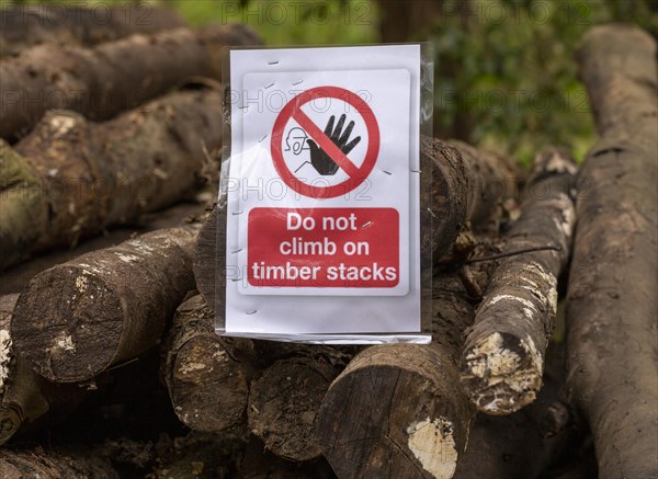 Do not climb on timber stacks sign on pile of logs, Sutton, Suffolk, England, UK