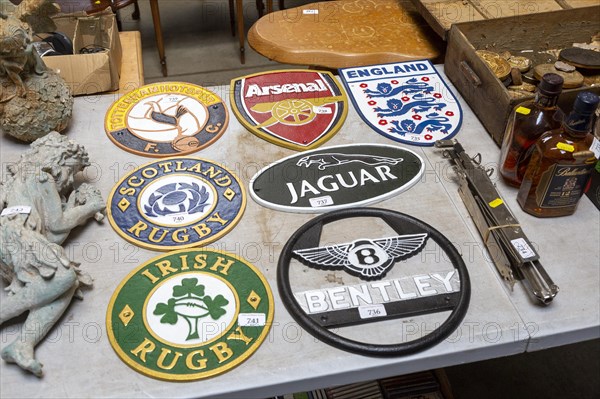 Replica cast iron metal plaques on table at auction, England, UK