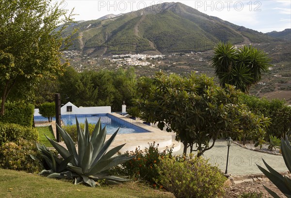 Swimming pool in garden small hotel view to Alcaucin village and Maroma mountain, Sierra de Tejeda, Axarquia, Spain, Europe