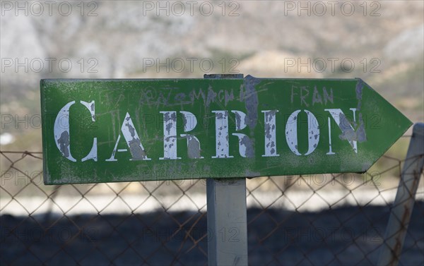 Road sign for small hamlet of Carrion, near Periana, Axarquia, Andalusia, Spain at base of limestone mountains