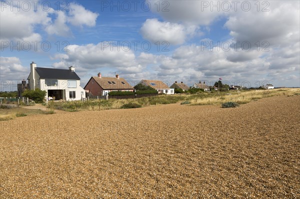 On the left is Ronina, former MOD house redesigned by Casswell Bank architects on beach at Shingle Street, Suffolk, England, UK