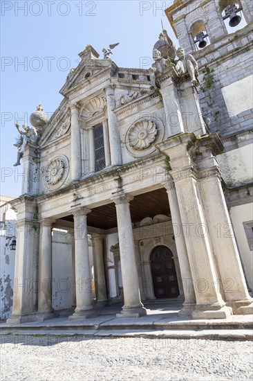 Sixteenth century church of Igreja de Nossa Senhora de Graca, Evora, Alto Alentejo, Portugal, southern Europe built in Italian Renaissance style facade having a portico with Tuscan columns architectural designs by Miguel de Arruda. Two stone Atlas-like figures sit on each corner nicknamed by locals the 'children of Grace', Europe