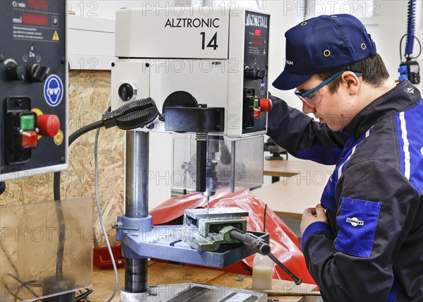 A trainee mechatronics technician works with a bench drill on a workpiece in a Deutsche Bahn training centre, Berlin, 07/02/2024
