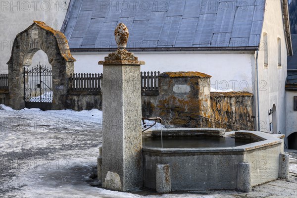 Stone fountain in front of the church, Guarda, Engadin, Grisons, Switzerland, Europe