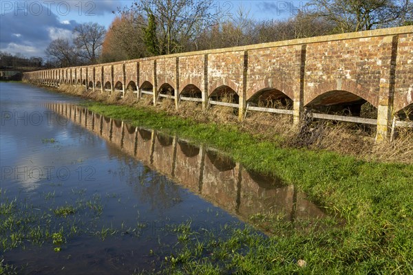 Arches of Maud Heath's causeway reflected by flood water, Kellaways, Wiltshire, England, UK