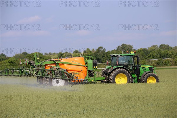 A farmer from the Schmitt vegetable farm in Hockenheim drives his tractor with a crop protection sprayer over his wheat field to combat brown rust and mildew (Hockenheim, Baden-Wuerttemberg)