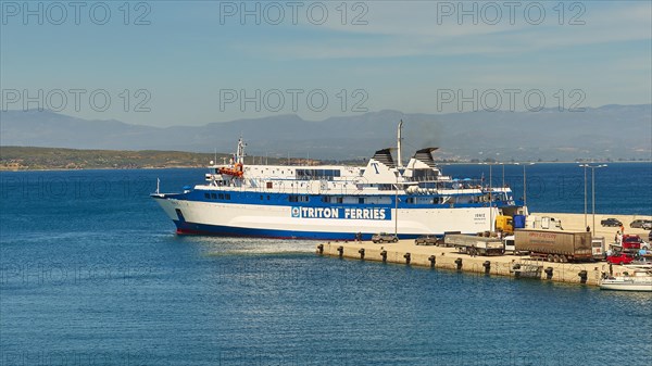 Ferry in the harbour loaded with trucks, surrounded by sea and mountains under a blue sky, Gythio, Mani, Peloponnese, Greece, Europe