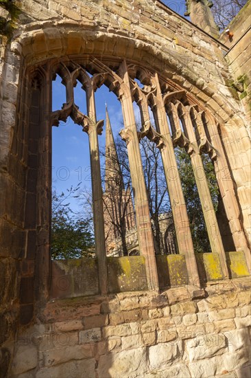 Steeple of Holy Trinity church seen through bombed out windows of old cathedral, Coventry, England, UK