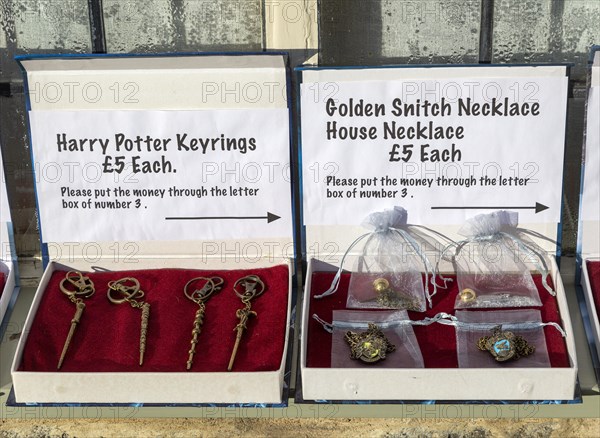 Display boxes Harry Potter souvenir products on sale on trust outside house, Lacock, Wiltshire, England, UK