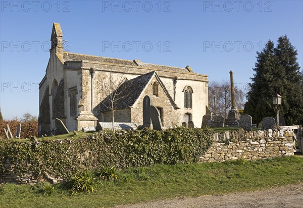 Building exterior historic church of Saint John, Inglesham, Wiltshire, England, UK 13th century building with 15th century churchyard cross