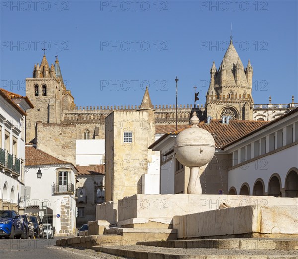 Fountain in the Largo das Portas de Moura with a view to the cathedral and surrounding historic buildings in the city centre of Evora, Alto Alentejo, Portugal, Southern Europe, 23 March 2019, Europe