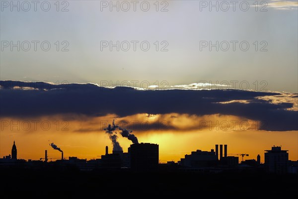 Plumes of smoke from the chimneys of a combined heat and power plant and a waste-to-energy plant at sunset, Berlin, 26/04/2021