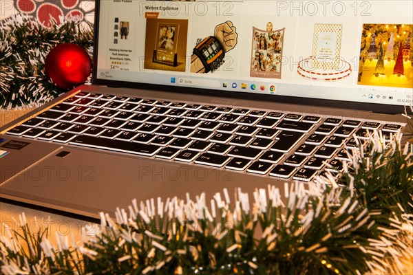 Symbolic image of Christmas shopping on the internet/at Amazon: Christmas decorations and laptop with open screen