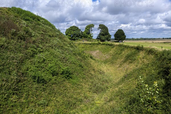 Deep defensive ditch and rampart at Old Sarum castle, Salisbury, Wiltshire, England, UK