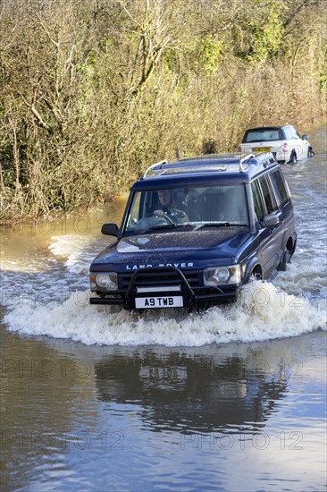 Land Rover Discovery Td5 vehicle driving through flood water at Kellaways, Wiltshire, England, UK 24/12/20