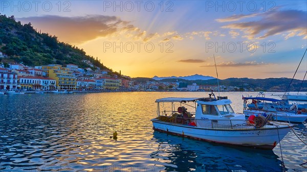 Harbour view at sunset with boats and glowing water reflections, Gythio, Mani, Peloponnese, Greece, Europe